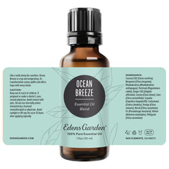 Edens Garden Ocean Breeze oil bottle beside candle for ambiance