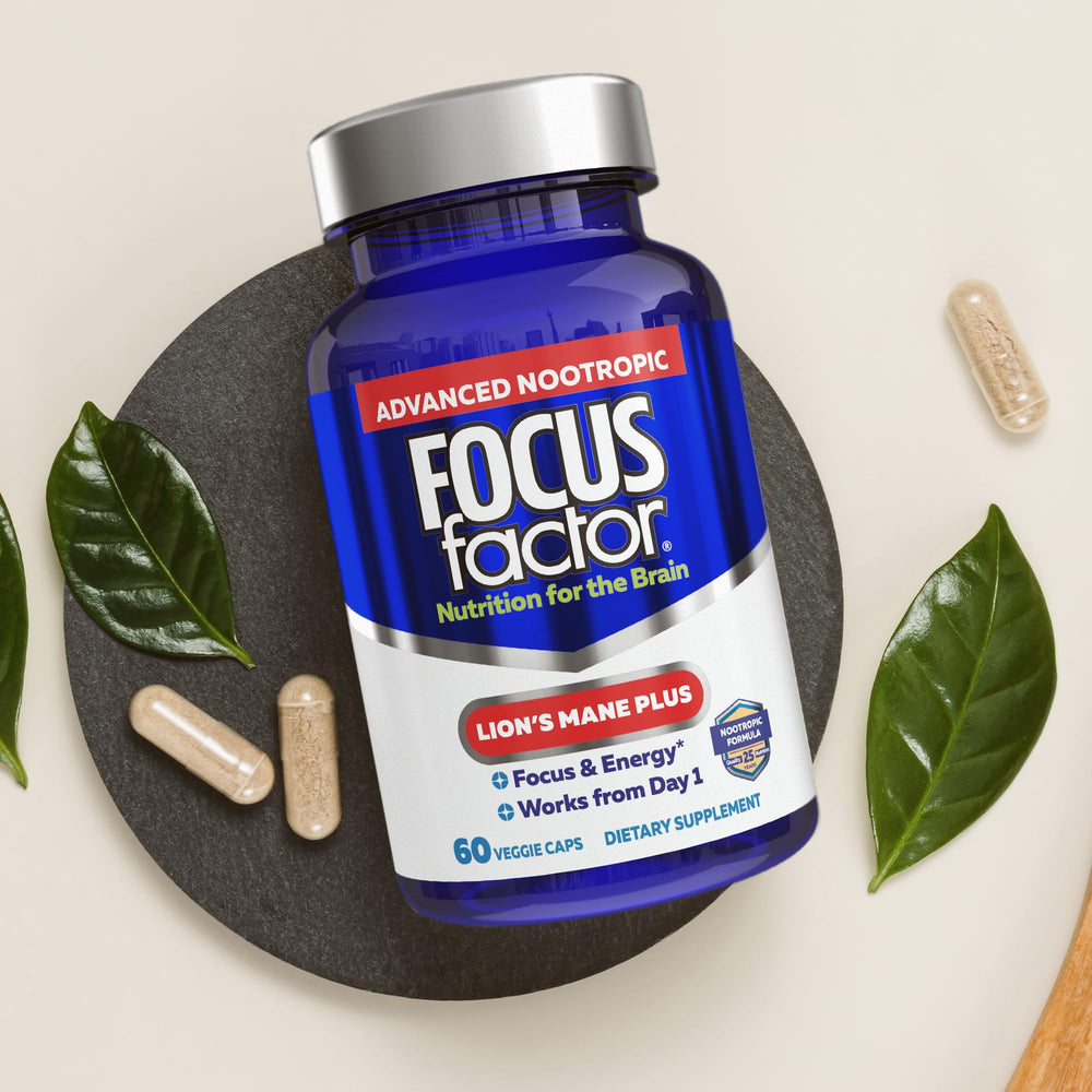Person taking Focus Factor Lions Mane Plus capsule during work