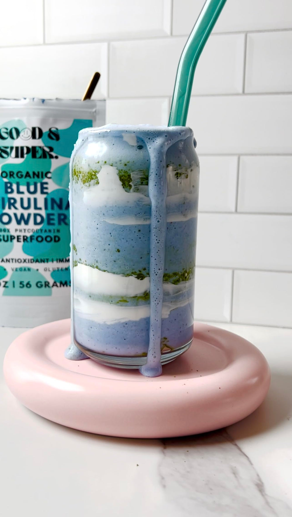 Pure water-extracted spirulina powder displayed beside jar on counter.