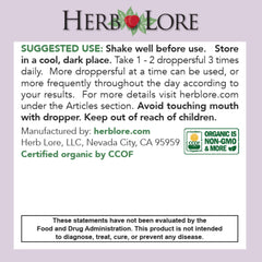 Hand holding dropper releasing tincture into a glass for easy dosing with Herb Lore.