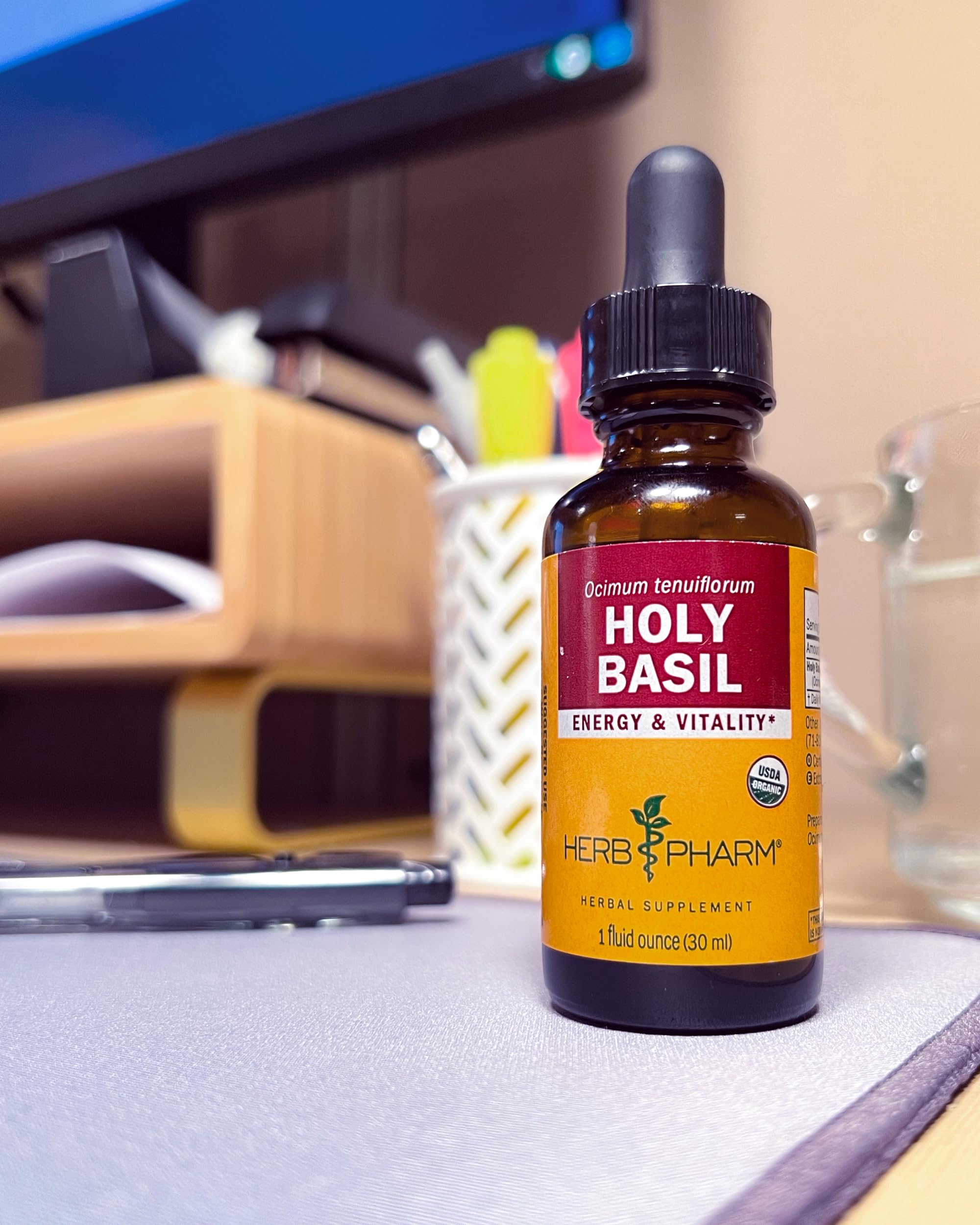 Pouring Holy Basil extract into water for quick absorption and flavor.