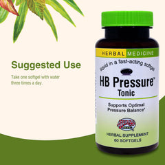 Glass of water with HB Pressure Tonic softgels ready to take