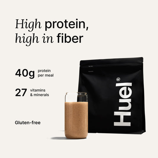 Huel Black Edition shaker cup pouring powder into a glass for quick shake.