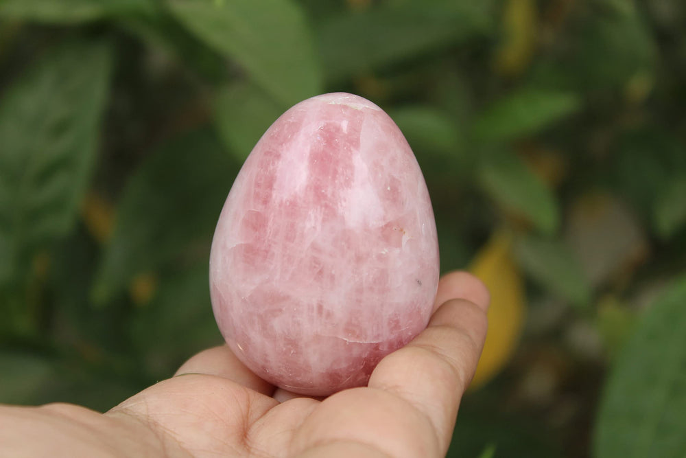 Jet International rose quartz egg on a stand for calm décor.