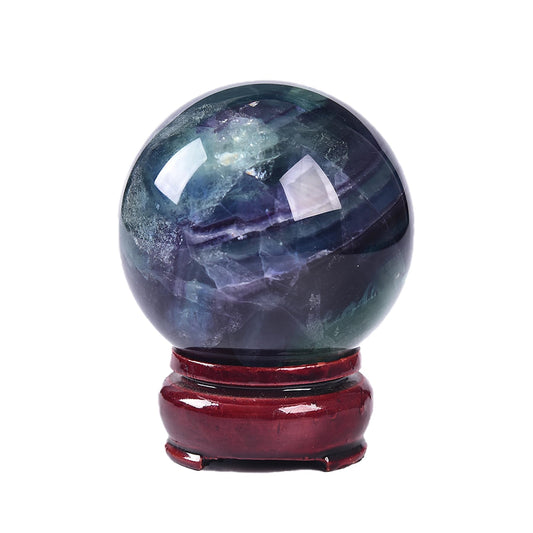 JIC Gem colorful fluorite sphere on a wooden stand for meditation and focus.
