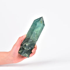 JIC Gem Green Fluorite obelisk wand resting on a wooden desk for energy work