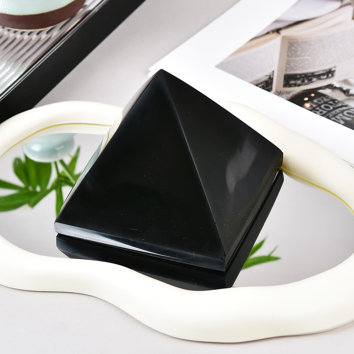 On a bookshelf, the pyramid adds a grounding accent