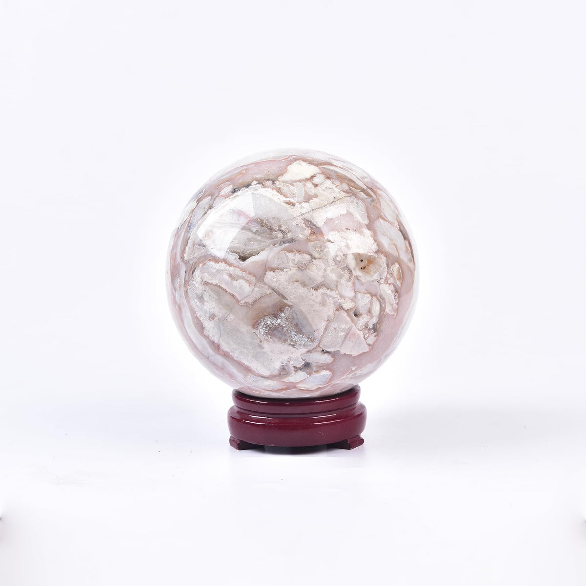 JIC Gem pink agate sphere on display stand for meditation and balance.