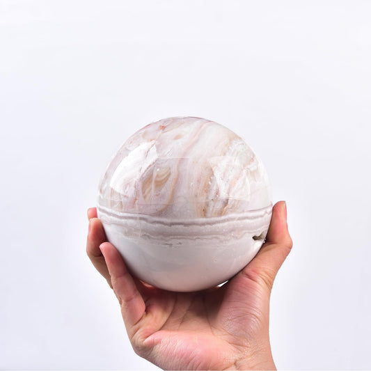 JIC Gem pink agate crystal ball showing natural textures on stand.