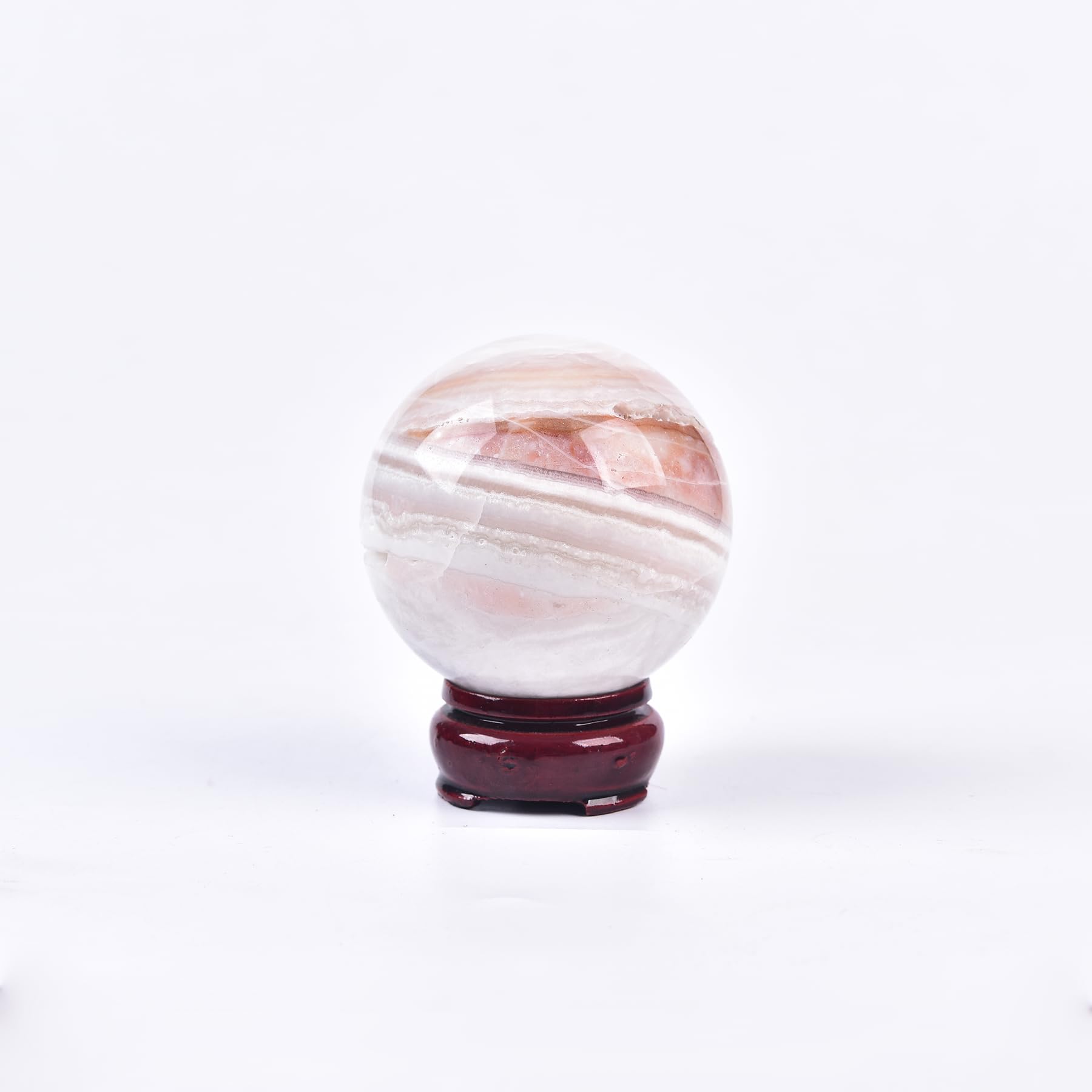 JIC Gem pink agate sphere on wooden stand, ideal meditation centerpiece.