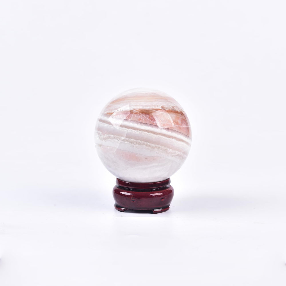 JIC Gem pink agate sphere on wooden stand, ideal meditation centerpiece.