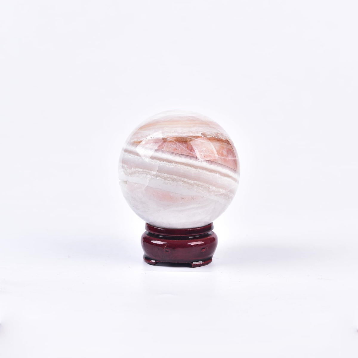 JIC Gem pink agate sphere on wooden stand, ideal meditation centerpiece.