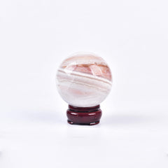 JIC Gem pink agate sphere on wooden stand, ideal meditation centerpiece.