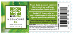 JustNeem Neem Cure Oil XL bottle on a skincare setup highlighting natural oils blend.