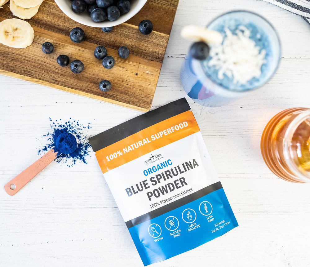 Lone Star Botanicals blue spirulina powder poured into a glass showcases vibrant natural color.
