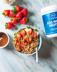 MRM Egg White Protein Chocolate in cup and spoon, easy to mix into smoothies.