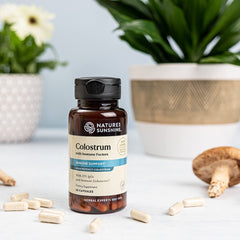 Nature's Sunshine Colostrum capsules arranged for daily gastrointestinal health support