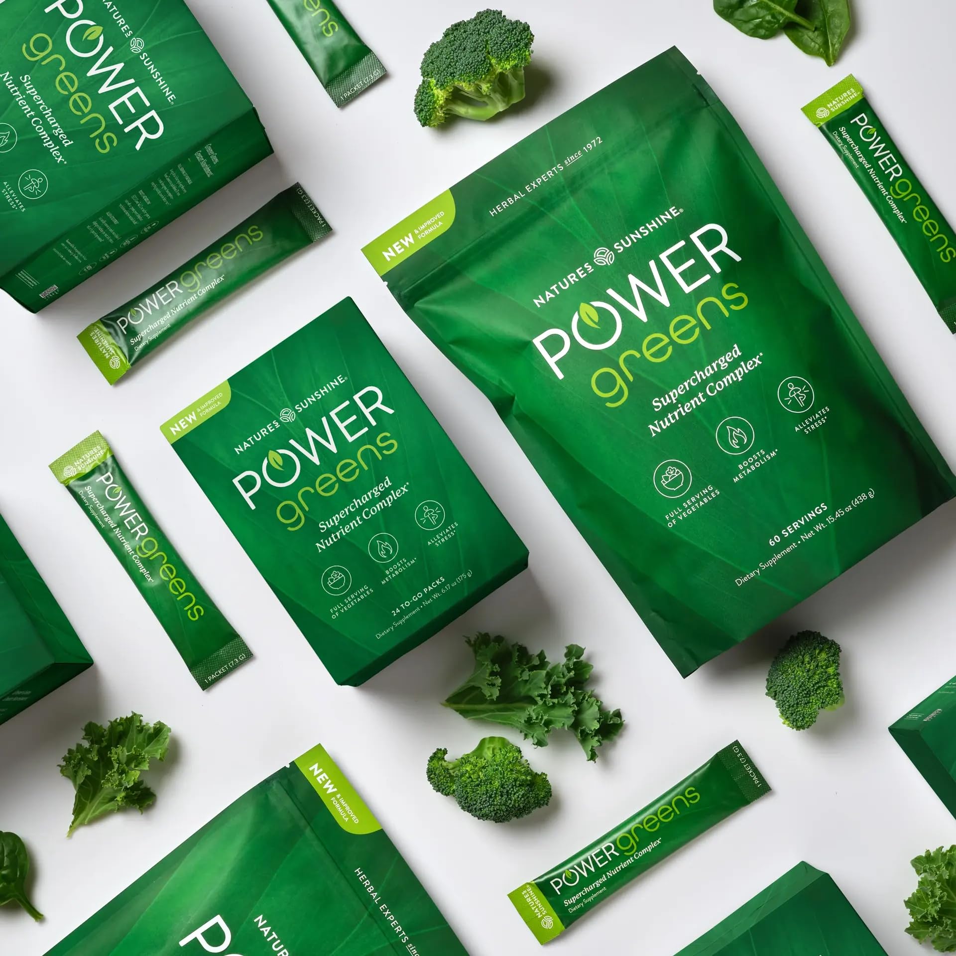 Nature's Sunshine Power Greens 24-stick bundle with fresh fruits and vegetables.