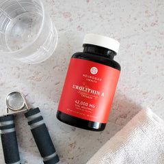Neurogan Urolithin A lifestyle-use scene with bottle and capsules.