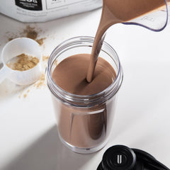 NOBULL protein shake in glass shows smooth texture for recovery after workouts.