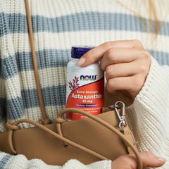 Close-up of NOW Foods Astaxanthin softgels showing natural color variation.