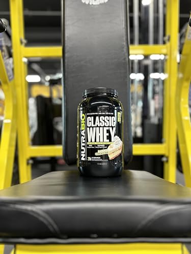 NutraBio Classic Whey powder being poured into a shaker.