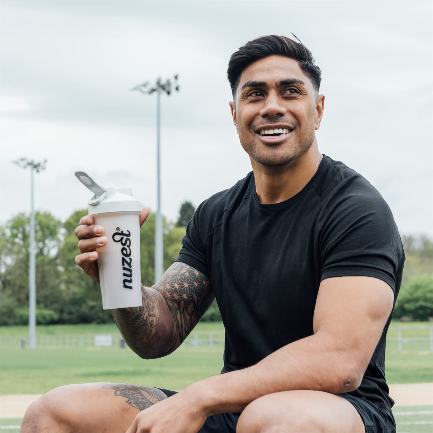Nuzest pea protein powder scoop chocolate; rich flavor for daily shakes.