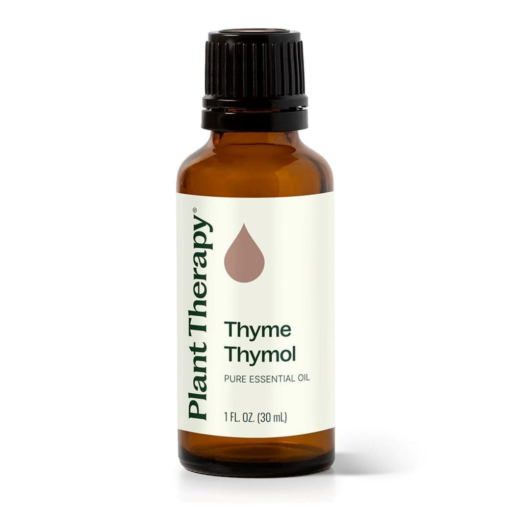 Plant Therapy Thyme Thymol oil pours from amber bottle, ideal for diffusion and seasonal comfort.