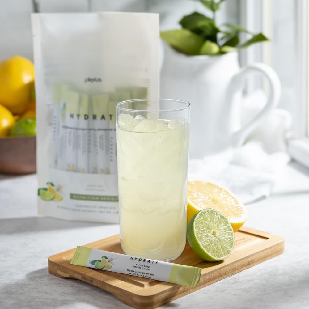 Plexus Hydrate Lemon Lime bottle beside a glass, ideal after travel or sun exposure.
