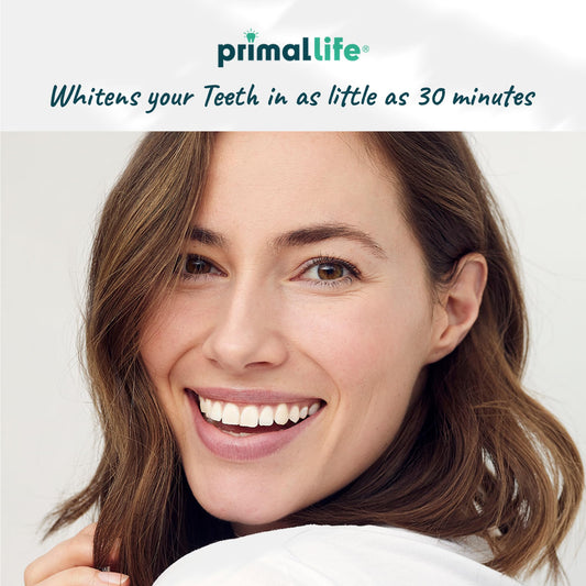 Primal Life Real White Strips being applied gel-side to upper and lower teeth.