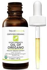 Oregano oil bottle with glass of water for easy intake.