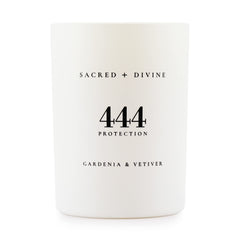 Sacred Divine 444 candle with gardenia and vetiver in a white jar enhances mood.
