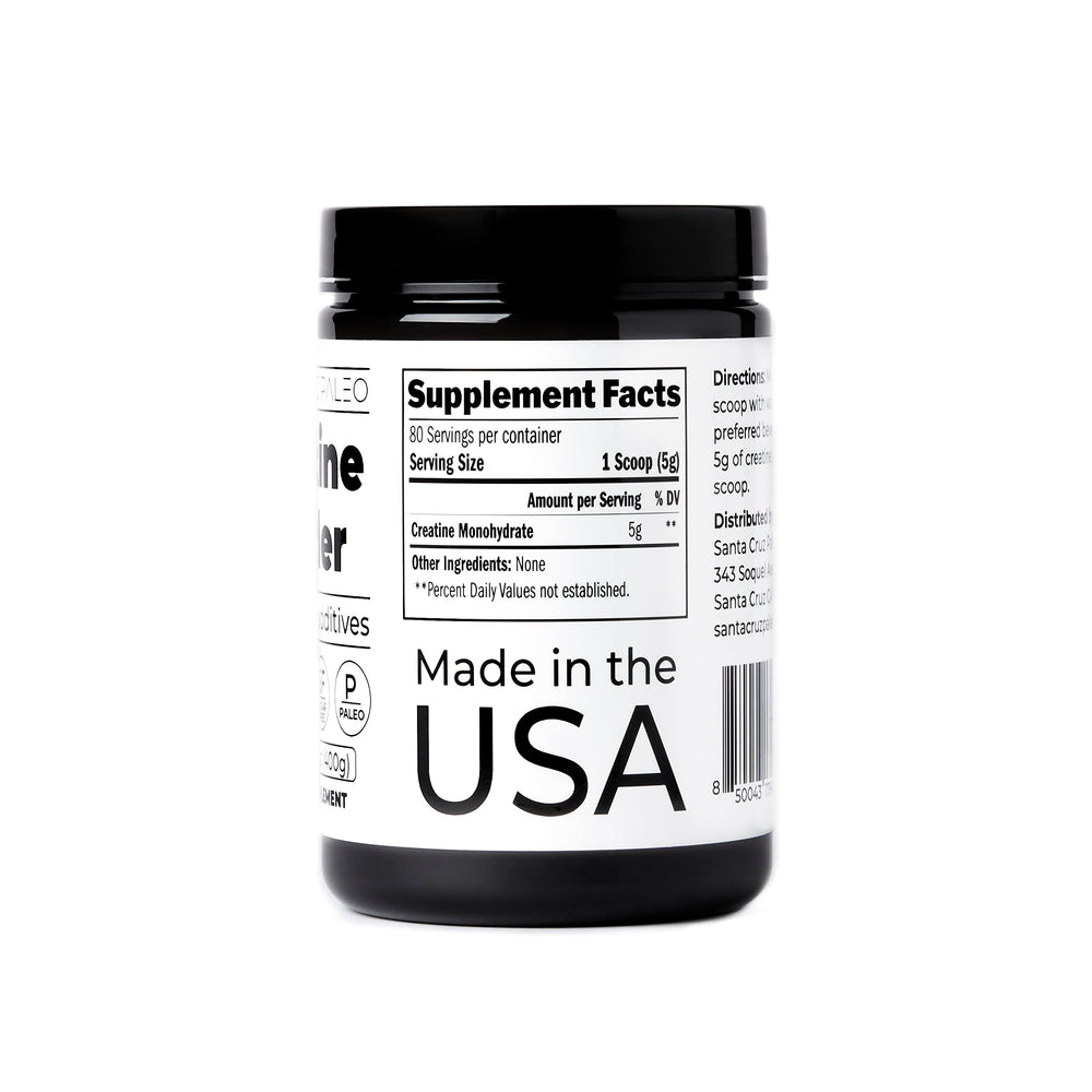 Santa Cruz Paleo creatine powder on a kitchen counter beside a protein shake.