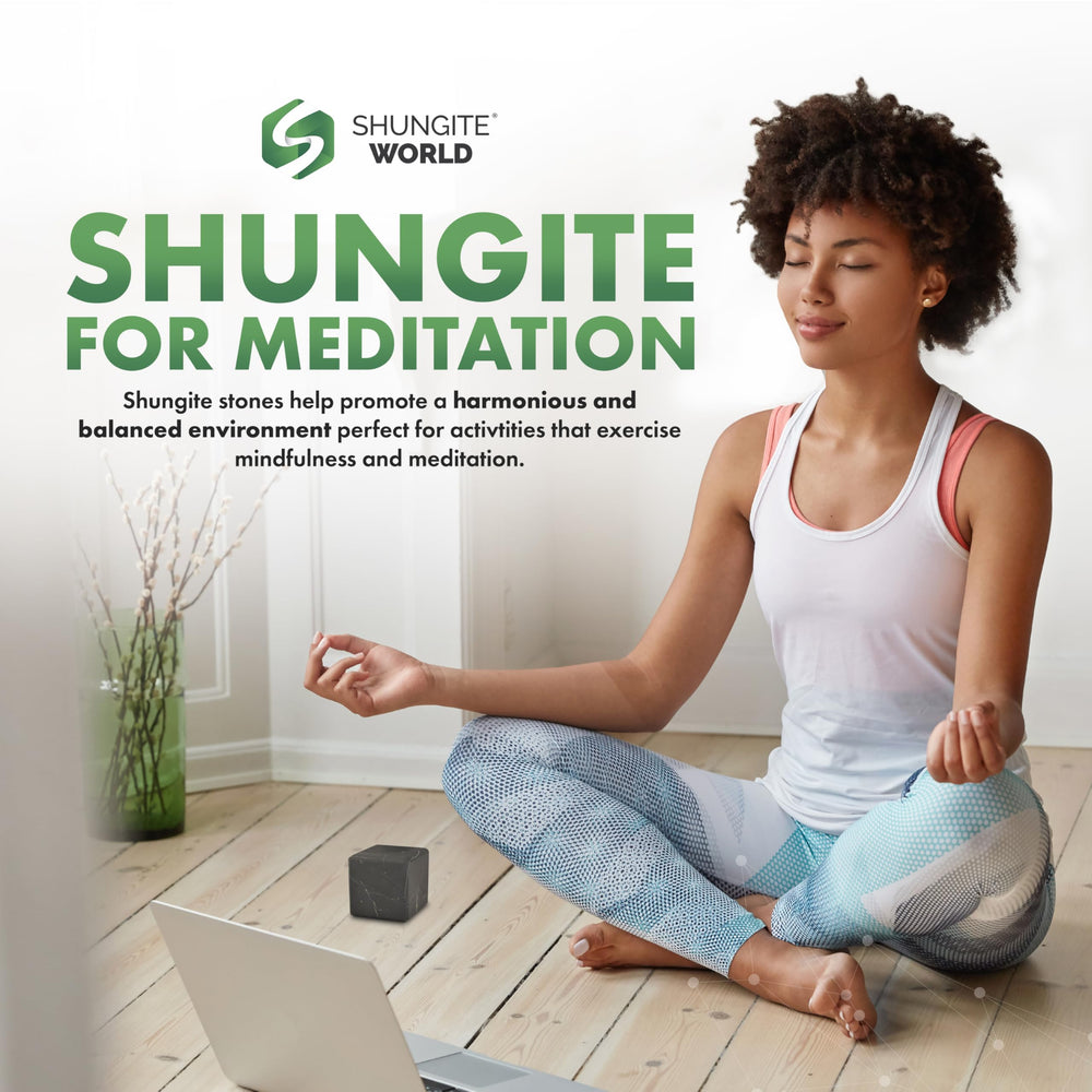 Shungite World cube beside laptop setup illustrating energy balancing near electronics.