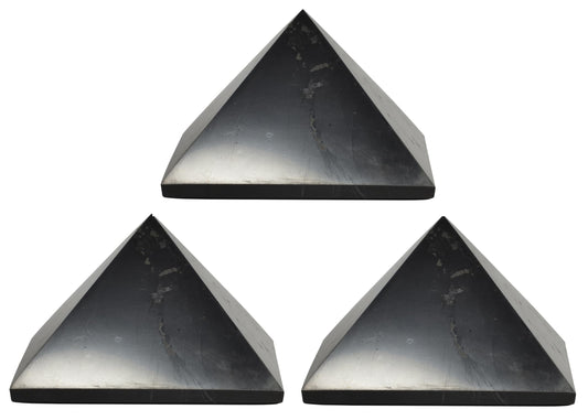 Shungite World 80mm pyramid in front view beside electronics for energy balance.