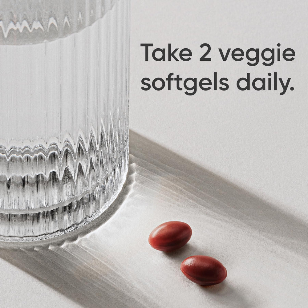 Close-up of plant-based softgel capsules ready for swallowing.