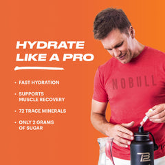 TB12 Electrolyte Powder Peach Mango dissolving in a glass with stirring