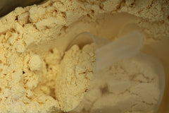 TGS Nutrition whey protein scoop beside a glass of post-workout shake