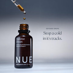Hands holding Defense Drops during travel to illustrate a portable wellness routine.