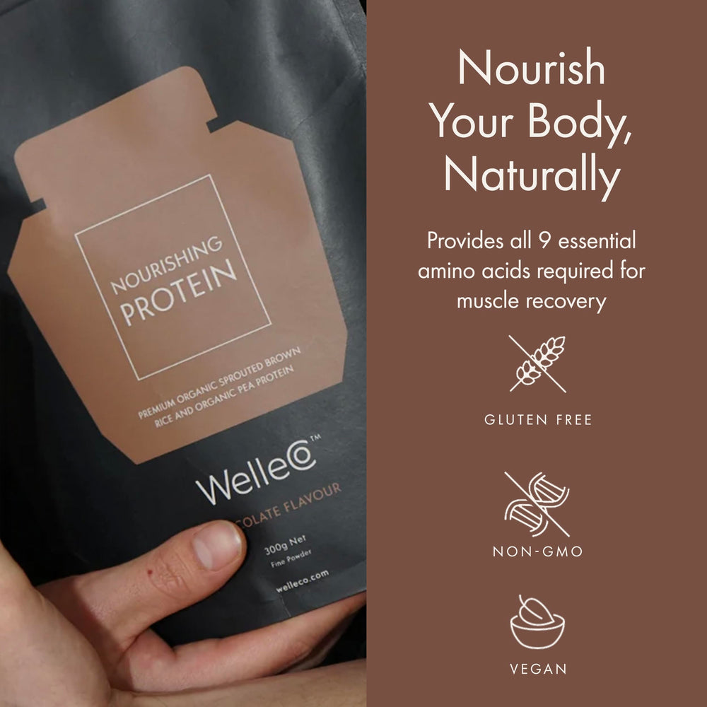 WelleCo chocolate protein powder tub open on kitchen counter with scoop.