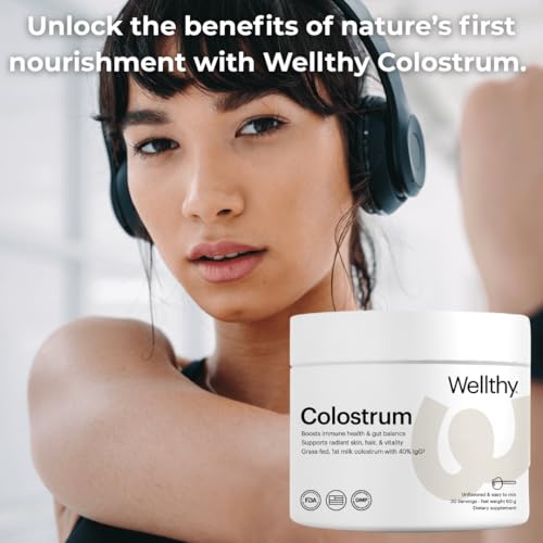 Wellthy Colostrum Powder scoop beside jar for daily dosage