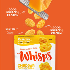 Whisps Cheddar snack board surrounded by nuts and fruit.