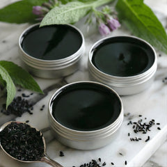 Wild Castle DNA Organics salve hand application shows easy outdoor relief for muscles.