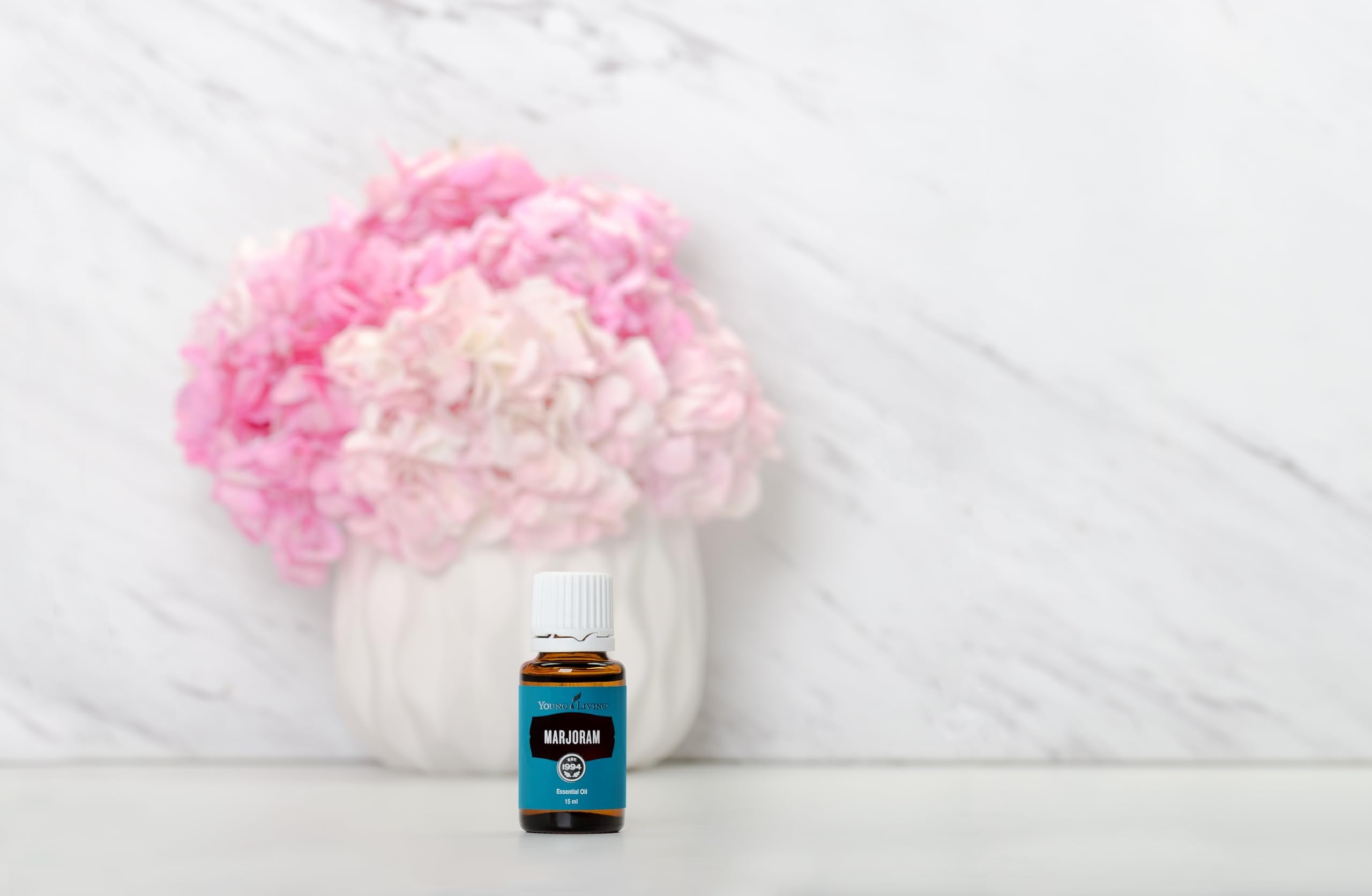 Young Living Marjoram bottle in a cozy self-care moment